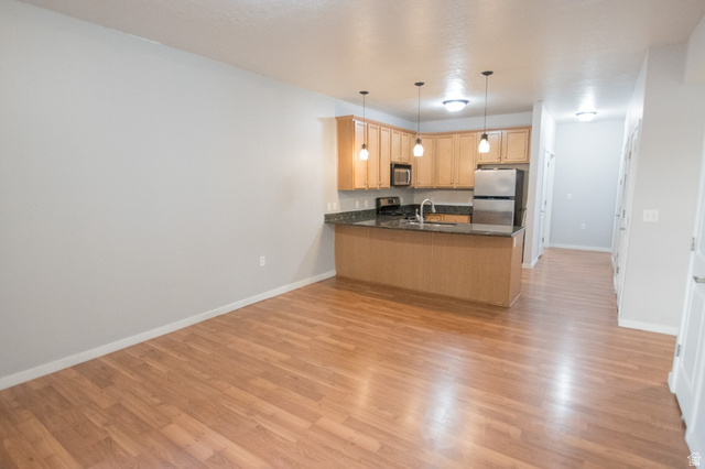 2150 South Main Street, Unit R405 Salt Lake City, UT 84115 - Photo 6 of 20 Open-concept living space featuring wood-finish flooring