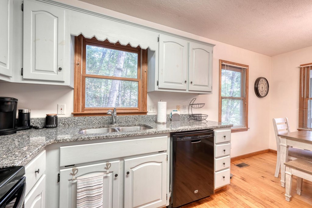 3739 Pat Colwell Road Blairsville, GA 30512 - Photo 18 of 55 a kitchen with granite countertop a sink stove top oven and cabinets