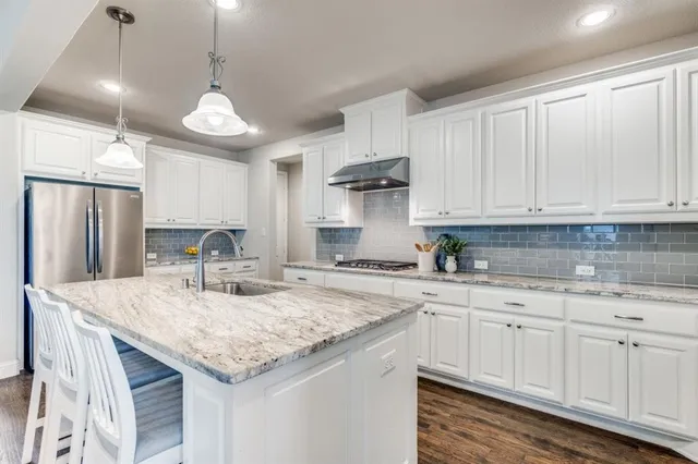 a kitchen with stainless steel appliances granite countertop a sink a stove and cabinets