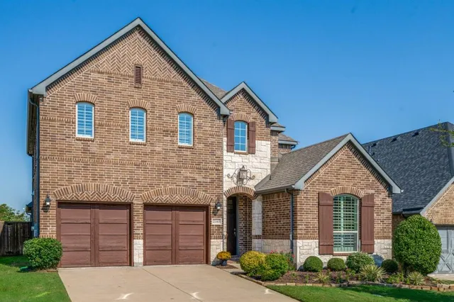 a front view of a house with yard and green space