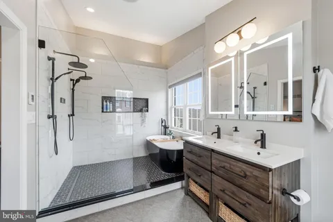 a bathroom with a double vanity sink mirror and shower