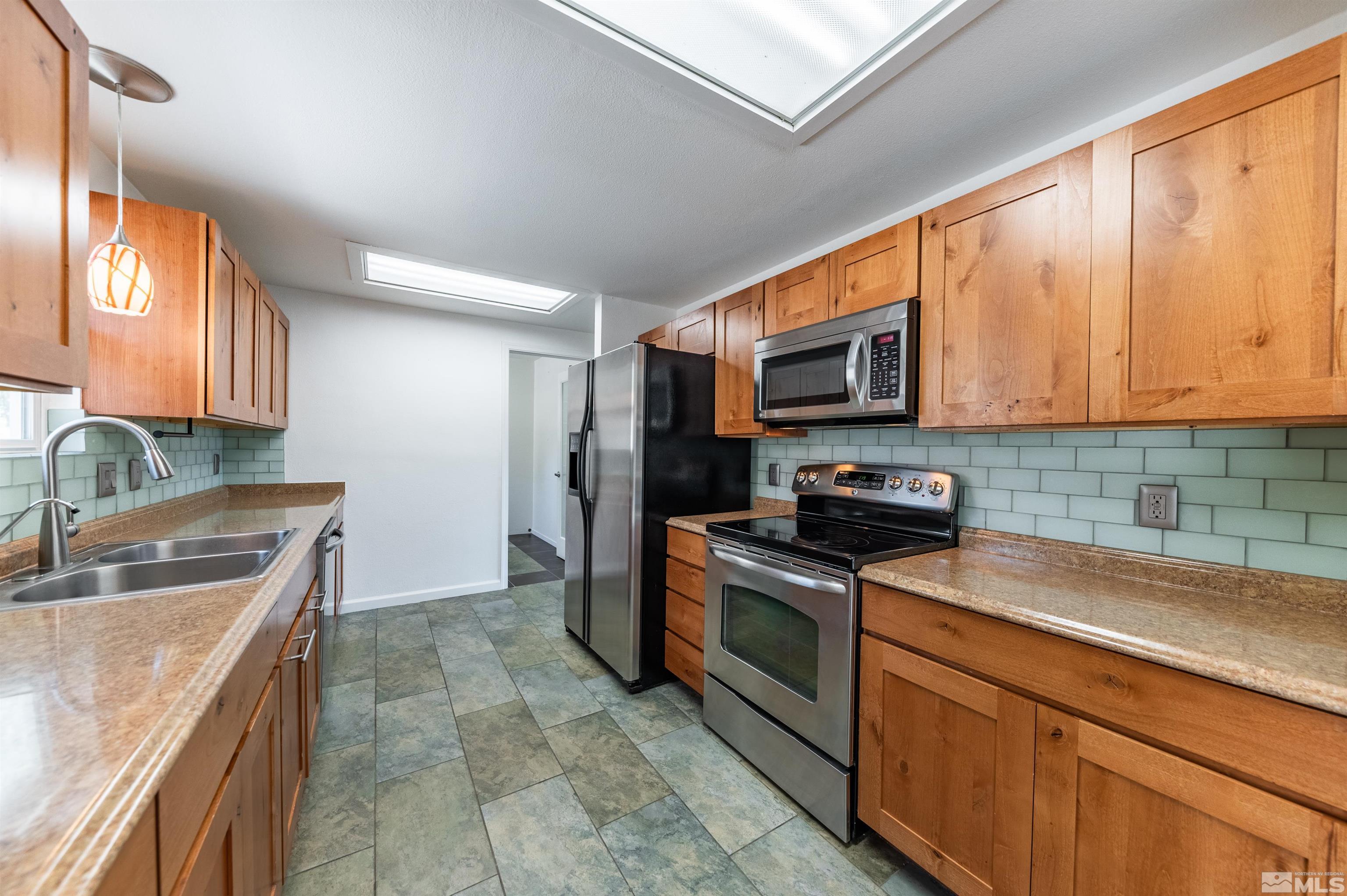 21940 Adobe Road Reno, NV 89521 - Photo 7 of 22 a kitchen with stainless steel appliances granite countertop a sink stove and microwave