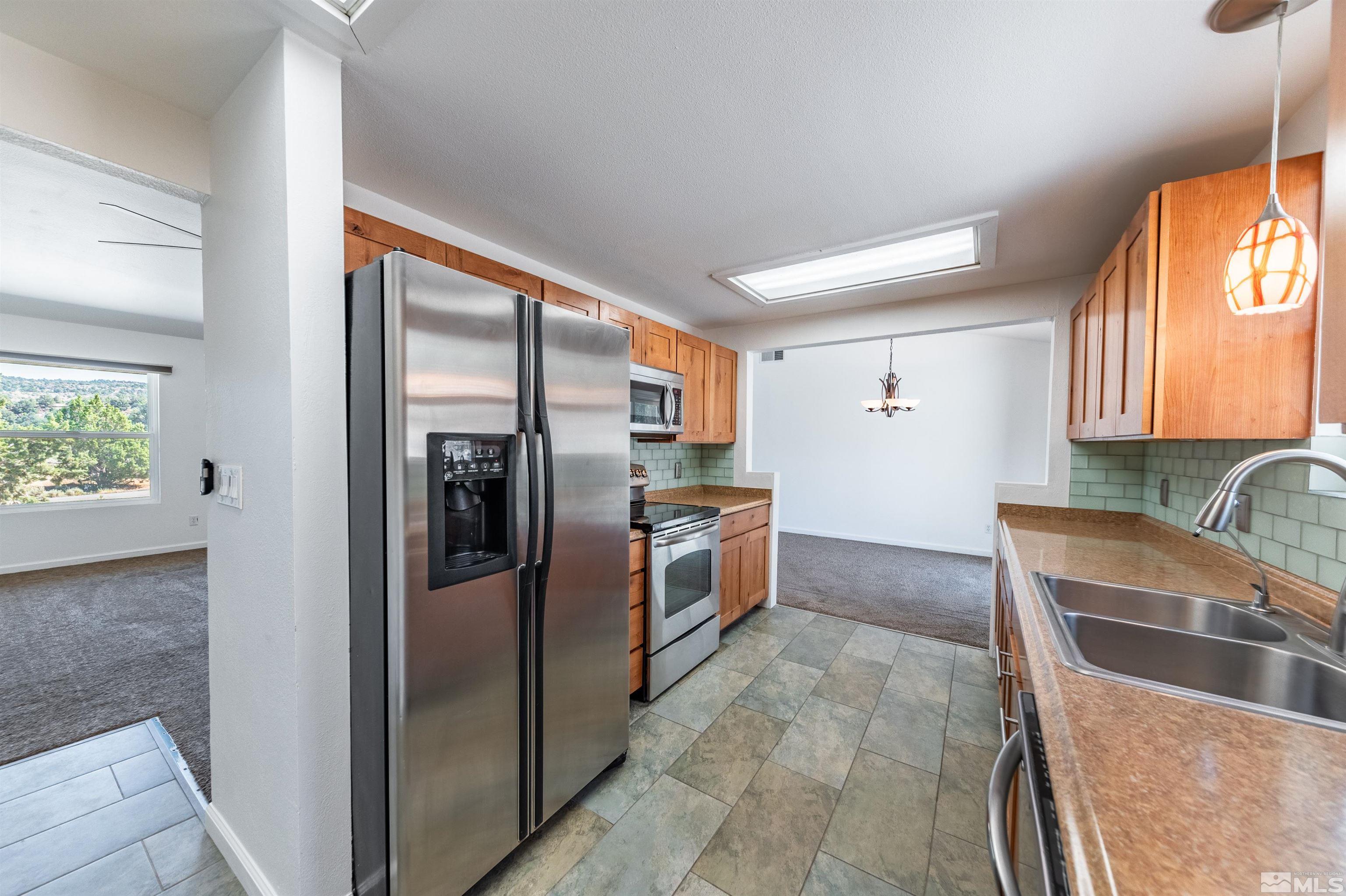 21940 Adobe Road Reno, NV 89521 - Photo 8 of 22 a kitchen with stainless steel appliances granite countertop a refrigerator and a sink