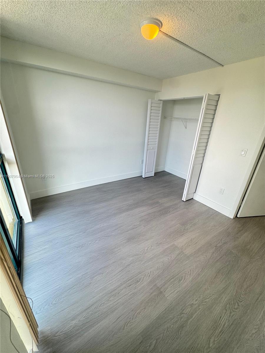 an empty room with wooden floor and entrance