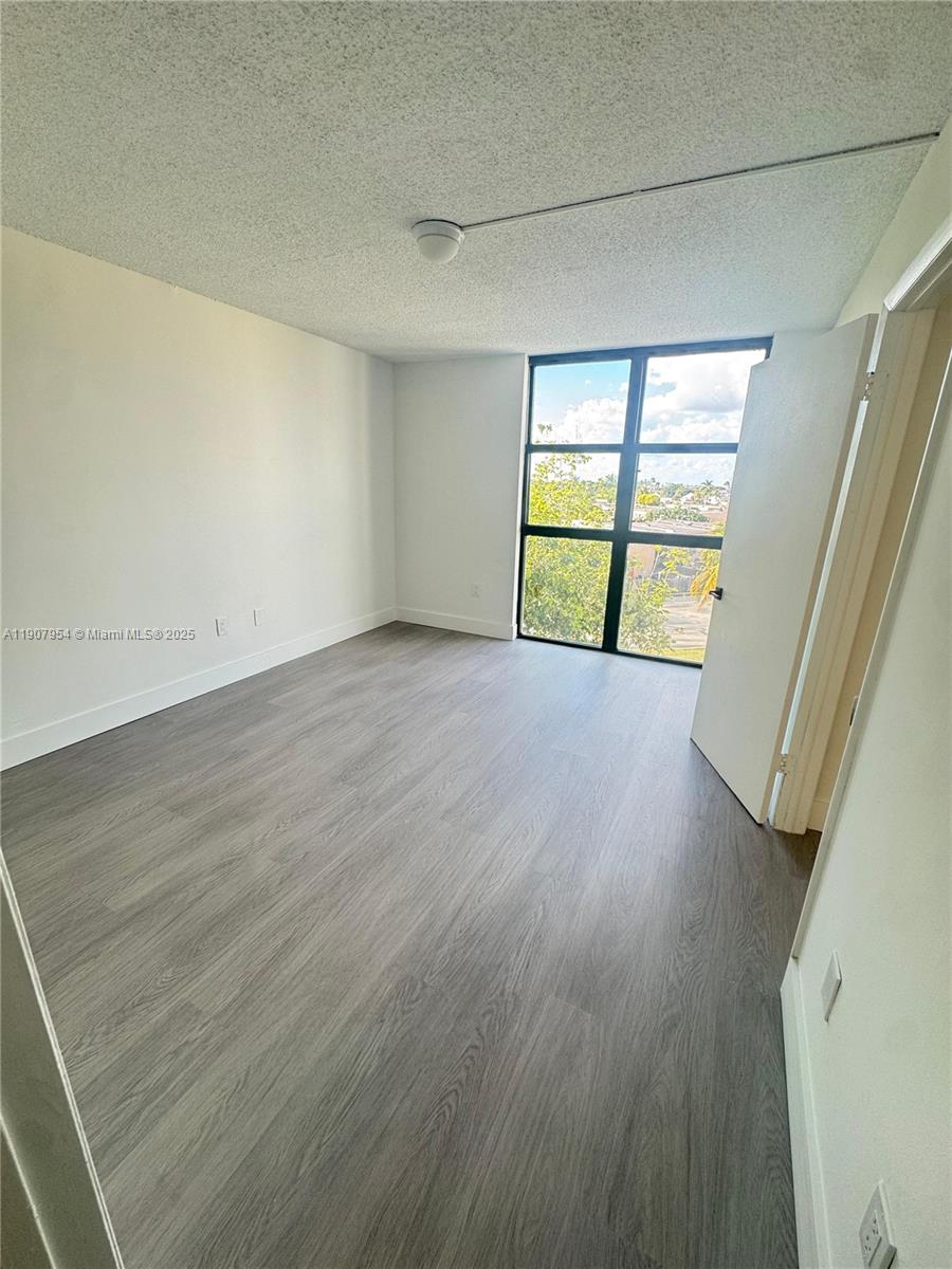 11780 Southwest 18th Street, Unit 5282 Miami, FL 33175 - Photo 16 of 19 an empty room with wooden floor and windows