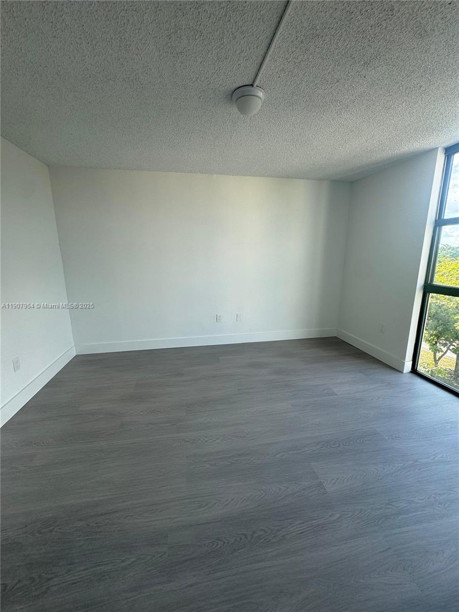 11780 Southwest 18th Street, Unit 5282 Miami, FL 33175 - Photo 18 of 19 an empty room with wooden floor and windows