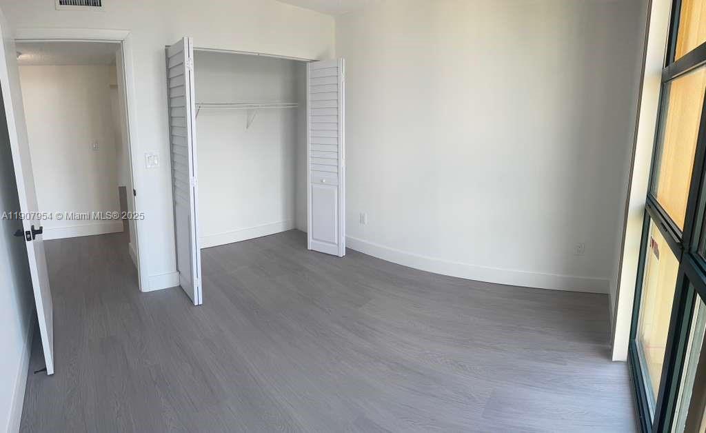 11780 Southwest 18th Street, Unit 5282 Miami, FL 33175 - Photo 7 of 19 an empty room with wooden floor and windows