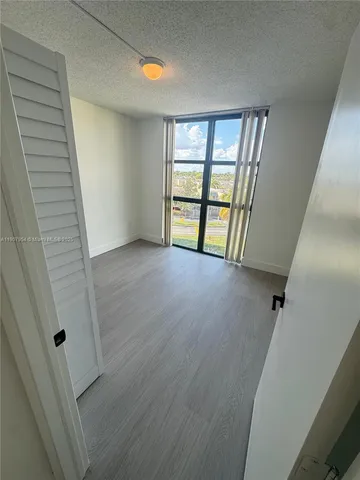 an empty room with windows and closet