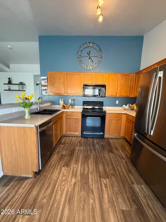 a kitchen with stainless steel appliances granite countertop a sink a stove cabinets and wooden floor