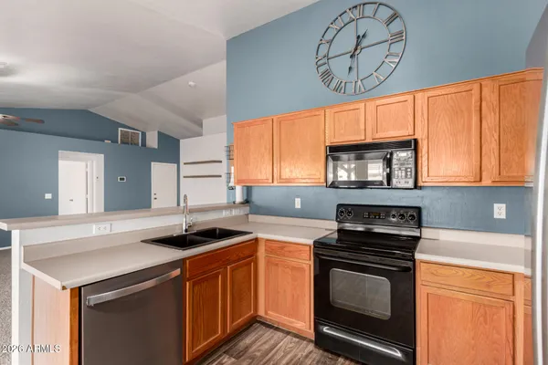 a kitchen with stainless steel appliances granite countertop a refrigerator a stove top oven and a sink