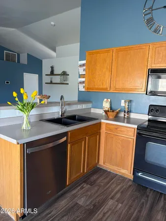 a kitchen with stainless steel appliances granite countertop a refrigerator a stove top oven a sink and dishwasher