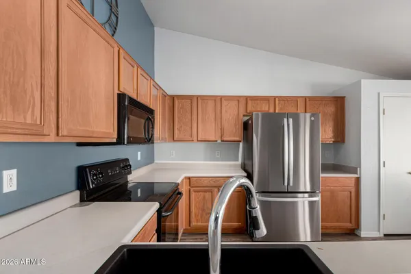 a kitchen with stainless steel appliances kitchen island granite countertop a stove a sink and a refrigerator
