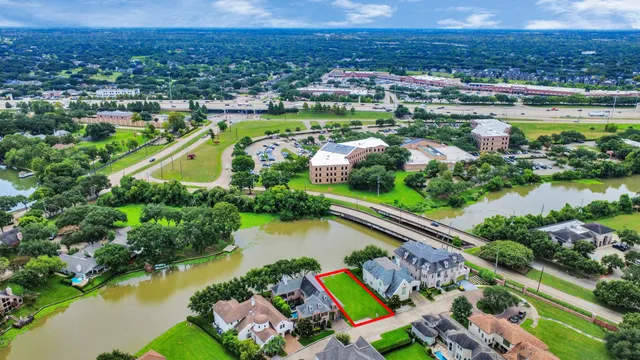 an aerial view of residential houses with outdoor space and trees