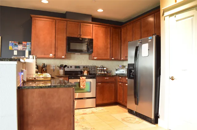 a kitchen with stainless steel appliances granite countertop a stove a sink and a microwave