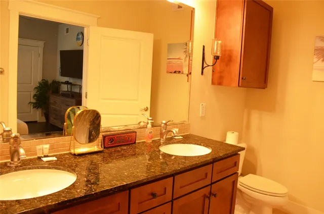 a bathroom with a granite countertop sink a mirror and a shower