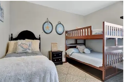 a kitchen with stainless steel appliances granite countertop a stove a refrigerator a kitchen island a dining table and chairs with wooden floor