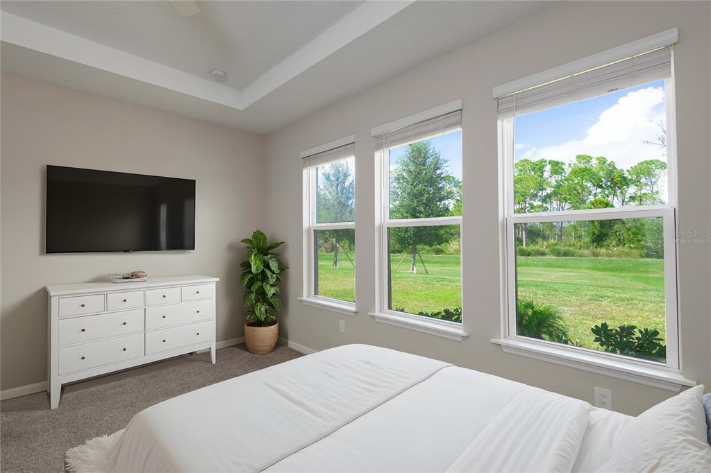 5604 Blue Reef Place Nokomis, FL 34275 - Photo 15 of 45 a bedroom with a bed flat screen tv and a window