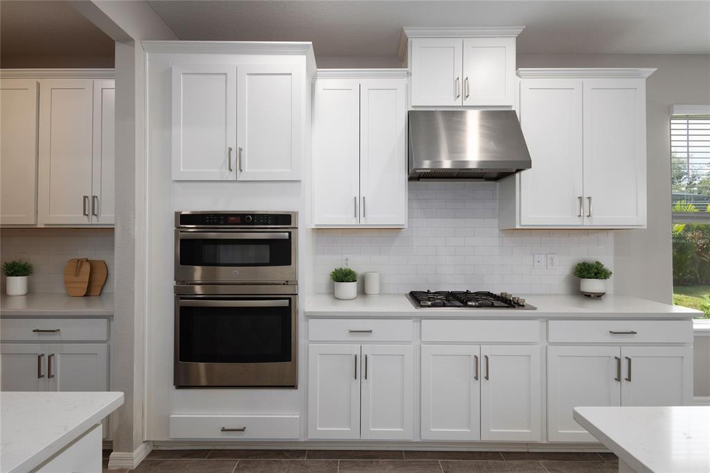 5604 Blue Reef Place Nokomis, FL 34275 - Photo 21 of 45 a kitchen with white cabinets and stainless steel appliances