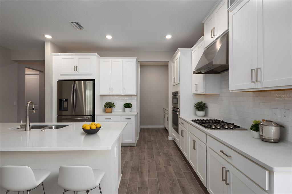 5604 Blue Reef Place Nokomis, FL 34275 - Photo 22 of 45 a kitchen with stainless steel appliances a white refrigerator a sink a stove and white cabinets