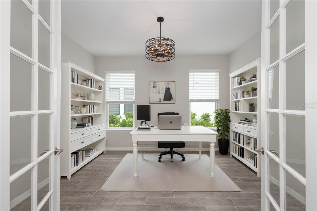 5604 Blue Reef Place Nokomis, FL 34275 - Photo 4 of 45 a workspace with furniture a rug and a book shelf