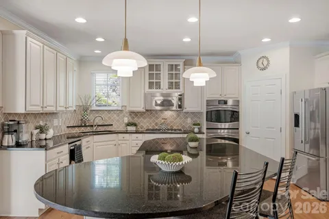 a kitchen with center island table and chairs in it