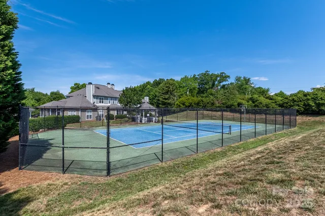a white house with a small yard and large trees