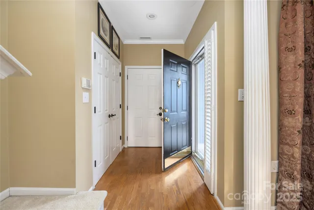 a view of a hallway with wooden floor and a bathroom