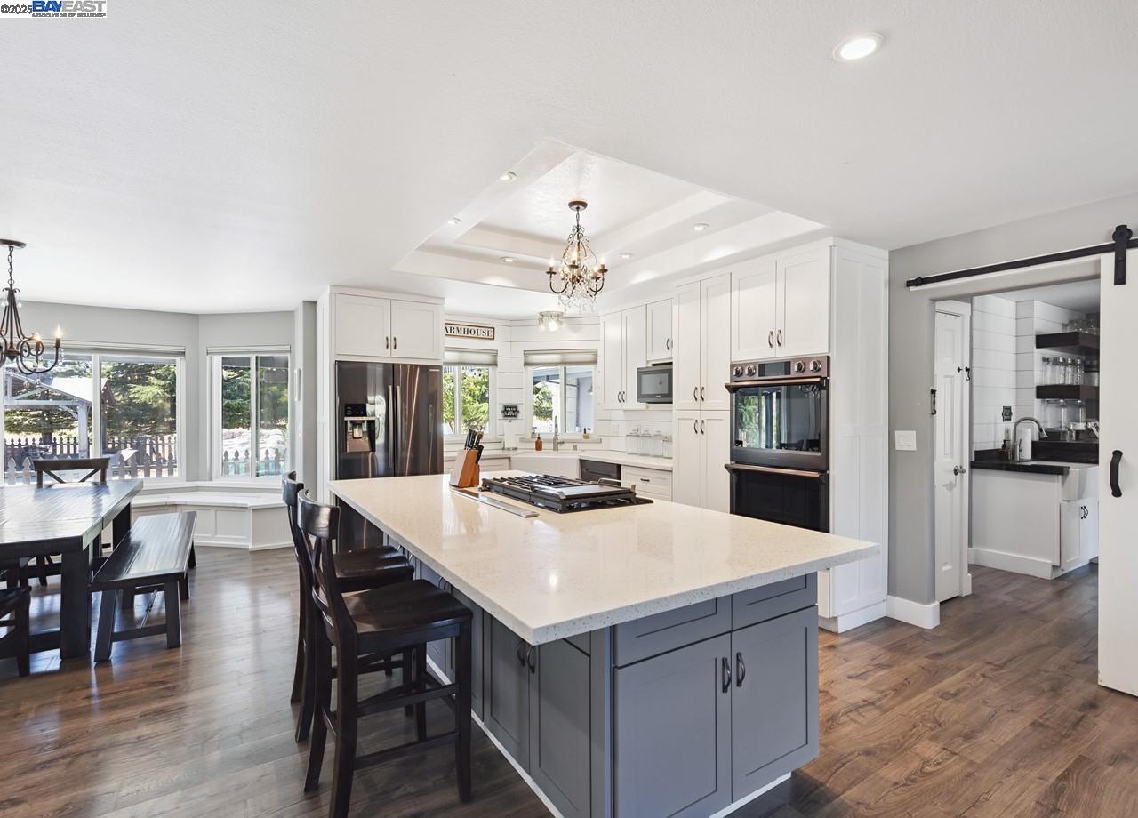 8191 Highland Road Livermore, CA 94551 - Photo 13 of 59 a kitchen with a stove a refrigerator and a dining table with wooden floor