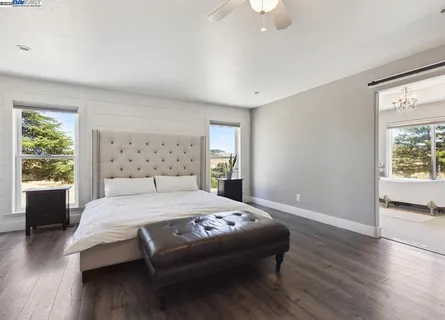 a spacious bedroom with a bed and a window with wooden floor