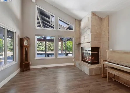 a view of a dining room and livingroom with furniture wooden floor a chandelier