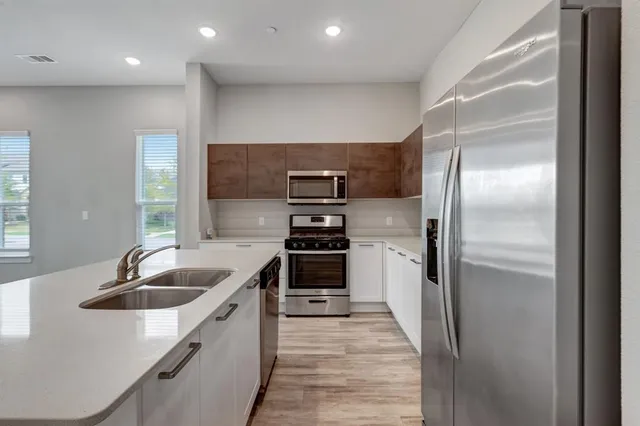 a kitchen with stainless steel appliances granite countertop a refrigerator and a sink