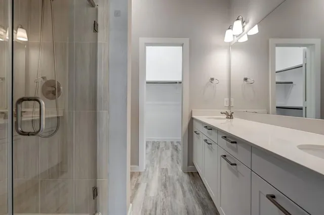 a spacious bathroom with a double vanity sink a shower and a mirror