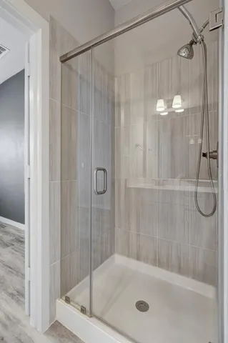 a bathroom with a shower and a glass door shower