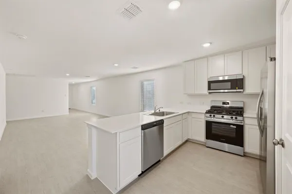 a kitchen with stainless steel appliances granite countertop a stove top oven a sink and dishwasher