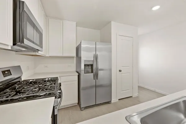 a kitchen with stainless steel appliances granite countertop a refrigerator and a stove top oven