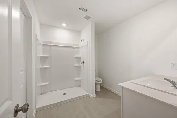 a bathroom with a shower a toilet and a shower