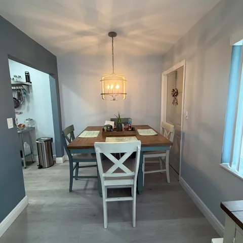 a dining room with furniture a chandelier and window