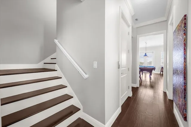 a view of a hallway with wooden floor and staircase