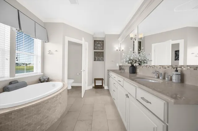 a spacious bathroom with a granite countertop tub sink and mirror
