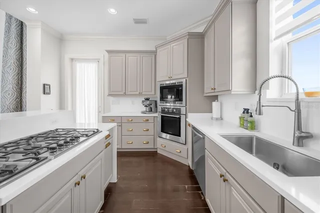 a kitchen with white cabinets and appliances