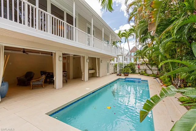 a view of a house with pool and chairs