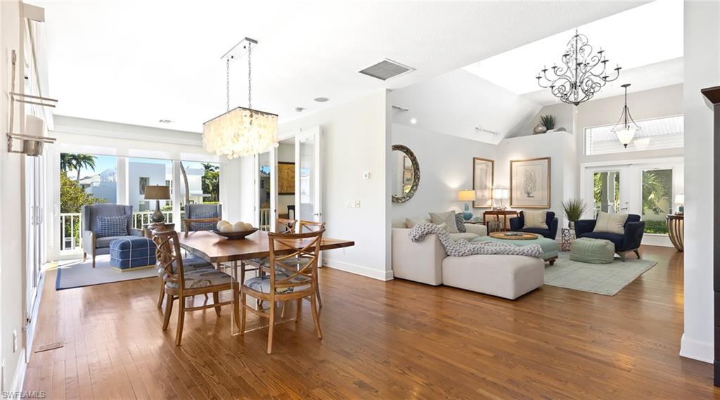 877 7th Street South Naples, FL 34102 - Photo 19 of 45 Dining area featuring suspended lighting, french doors, dark wood-style flooring, and vaulted ceiling