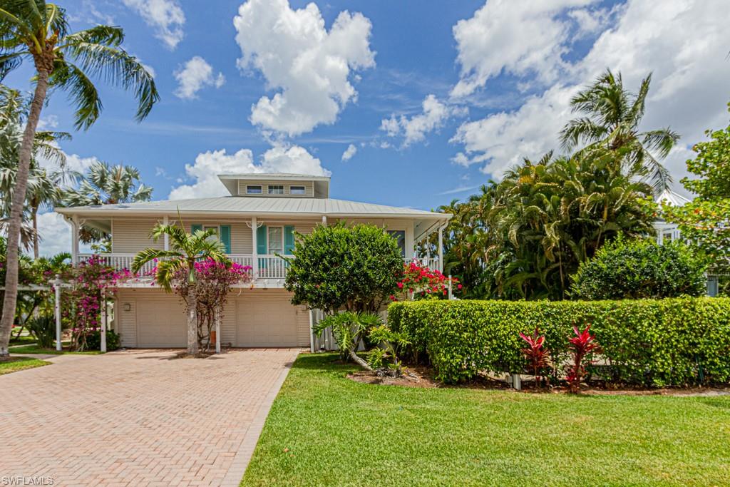 877 7th Street South Naples, FL 34102 - Photo 3 of 25 a view of a house with a big yard and potted plants