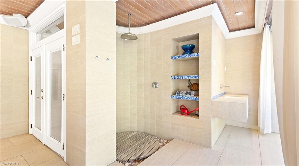 877 7th Street South Naples, FL 34102 - Photo 32 of 45 Bathroom featuring a walk in shower, wooden ceiling, built in shelves, light tile patterned floors, and tile walls