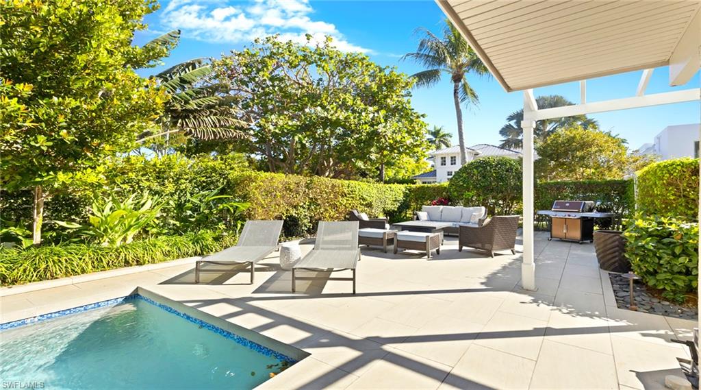 877 7th Street South Naples, FL 34102 - Photo 33 of 45 View of pool featuring an outdoor lounge area, patio surround, and a grill