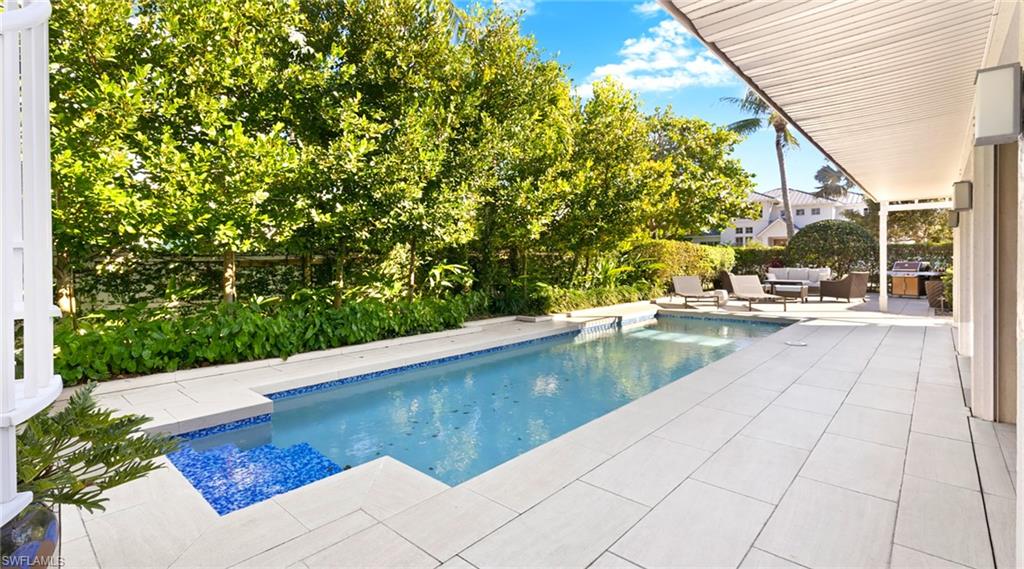877 7th Street South Naples, FL 34102 - Photo 35 of 45 Swimming pool featuring a patio area, outdoor seating, and a grill