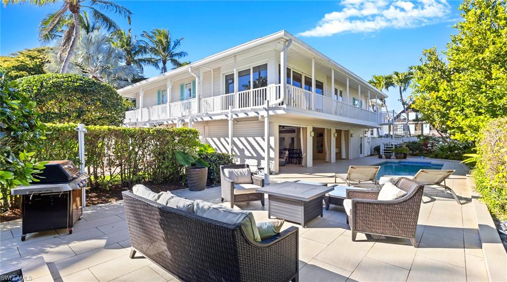 877 7th Street South Naples, FL 34102 - Photo 39 of 45 Rear view of property featuring a patio, outdoor lounge area, an outdoor pool, and a balcony