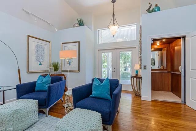 a living room with furniture a wooden floor and a chandelier