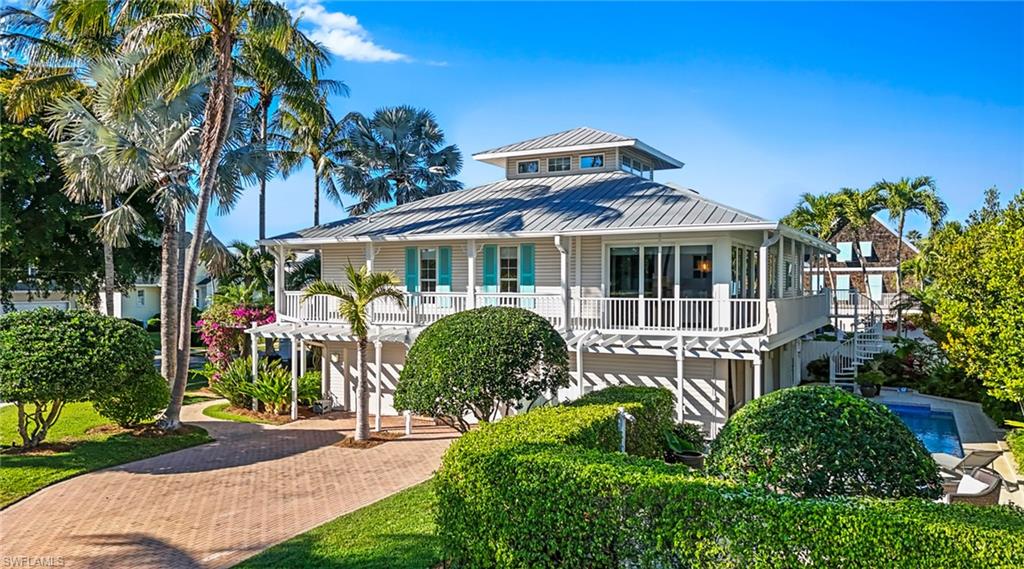 877 7th Street South Naples, FL 34102 - Photo 41 of 45 Coastal inspired home with decorative driveway, a standing seam roof, and a balcony