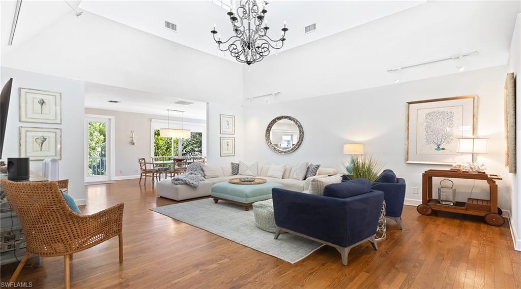 877 7th Street South Naples, FL 34102 - Photo 7 of 45 Living area with hardwood / wood-style floors, a high ceiling, and suspended lighting